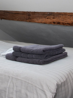 Handdoeken en sloffen op bed